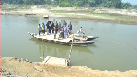 ঘাঘট নদীর ত্রিমোহিনী ঘাটে নৌকায় পাড় হচ্ছে মানুষ। ছবি: খোলা কাগজ 