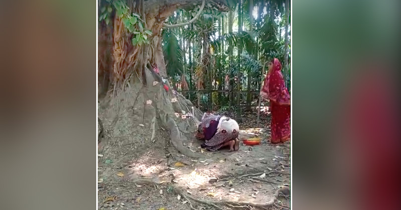 কালের সাক্ষী হয়ে দাঁড়িয়ে থাকা বটগাছতলায় পূঁজা করছে হিন্দু সম্প্রদায়ের লোকজন | ছবি : খোলা কাগজ